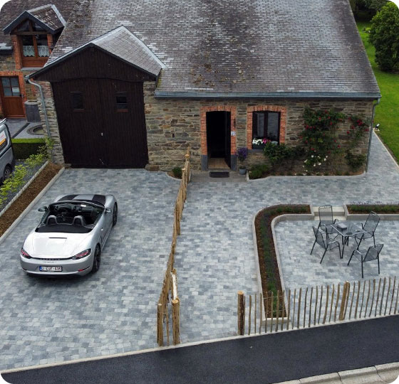 allée en pavé en pierre devant une facade de maison avec voiture